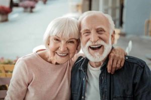 a couple smiling with their all on 4 dental implants