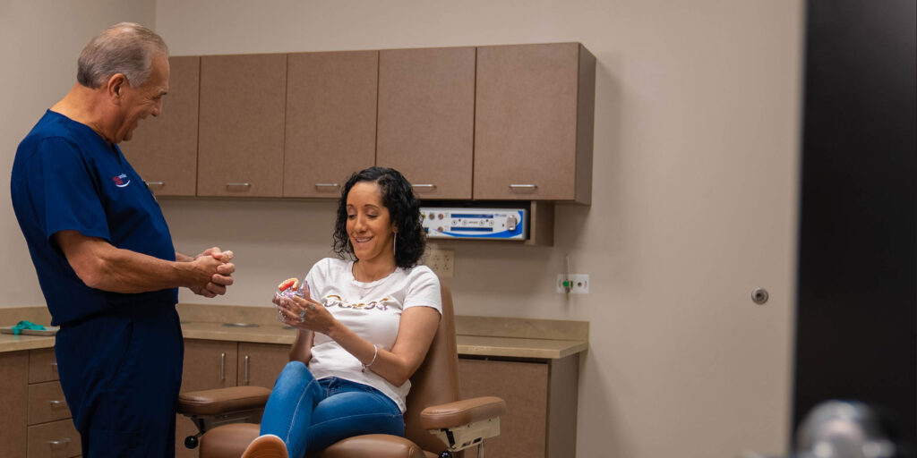 Patient holding a model of dental implants