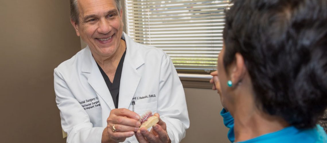 Dr. Halusic Showing A Dental Patient A Full Arch Dental Implant Model